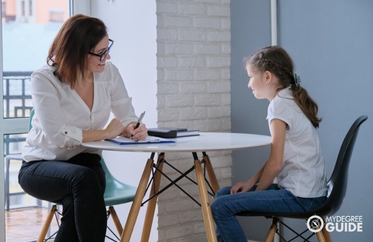 school psychologist talking to a young student