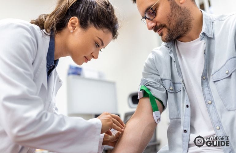 Phlebotomist extracting patient's blood