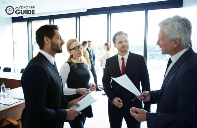 politicians discussing their reports with each other in a conference room