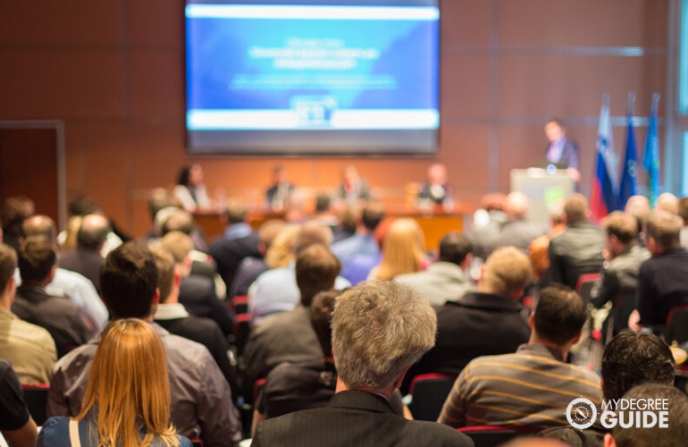 professionals listening to speaker during conference