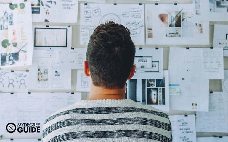 man checking project management pinboard