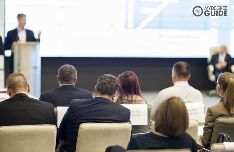 people in a conference listening to the speaker