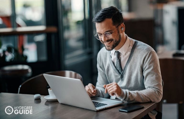 doctorate of education student working on laptop at coffee shop