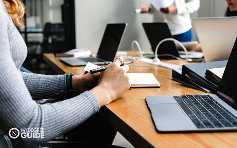 sitting in meeting with computer