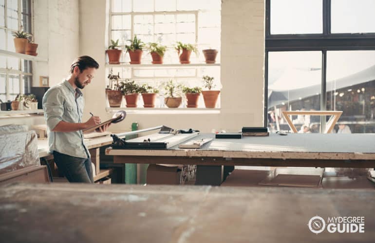 small business owners checking inventory on his clipboard