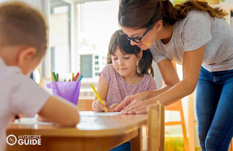 special education teacher teaching her student how to write