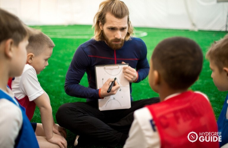 personal trainer teaching sports to young children