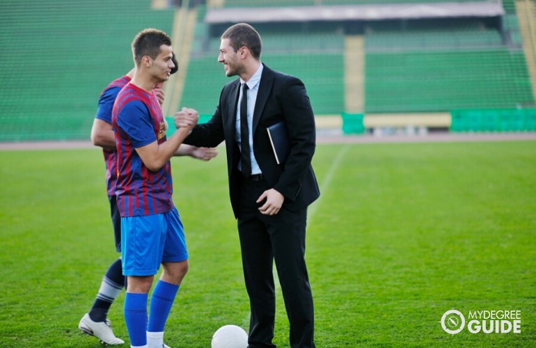 sports manager talking to football players