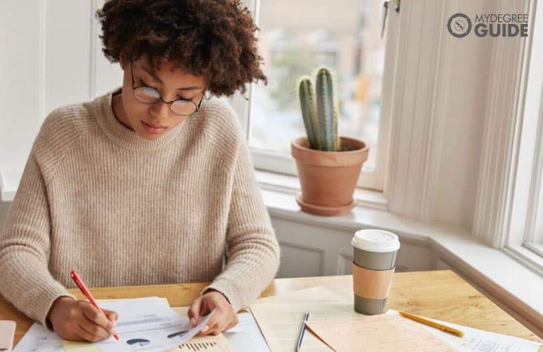 female statistician working on documents in her office table