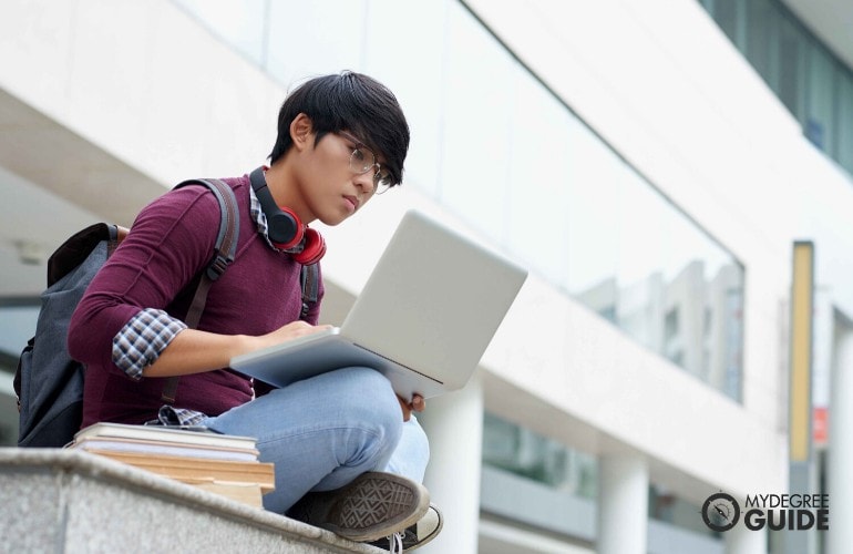 student typing on his computer