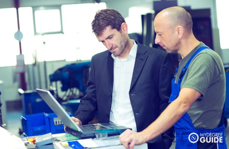 Industrial Production Manager mentoring an employee