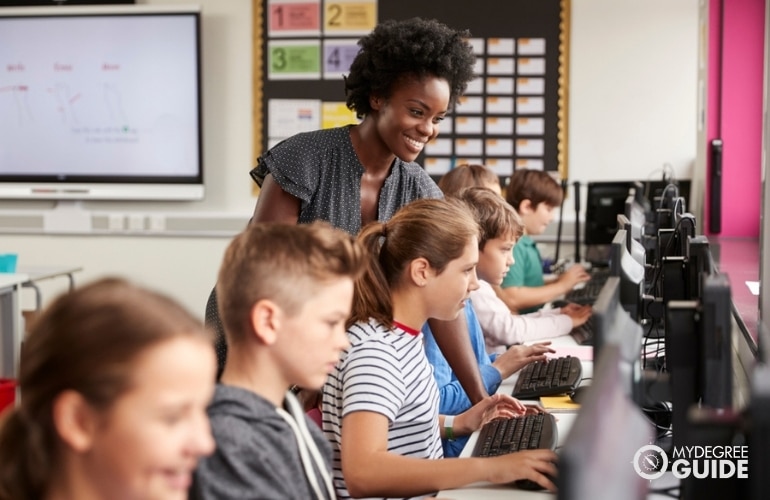 teacher with students during computer class