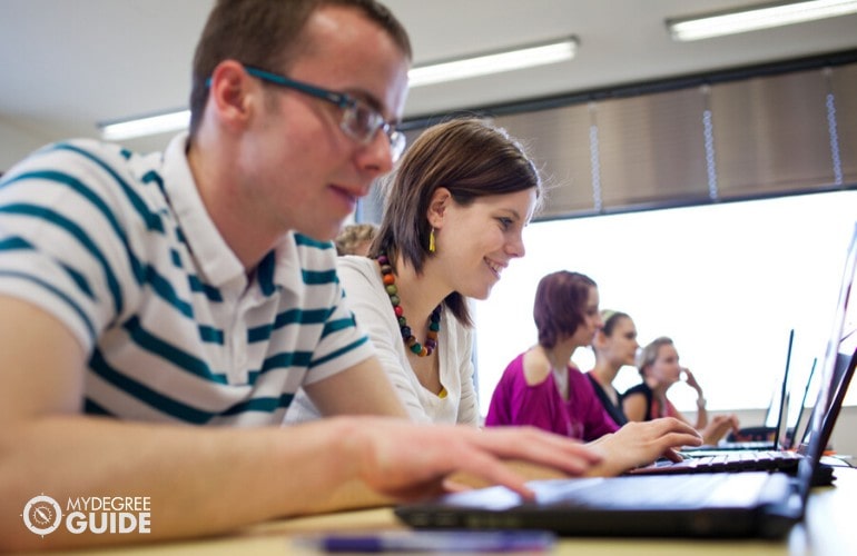 accounting students studying together on their laptops