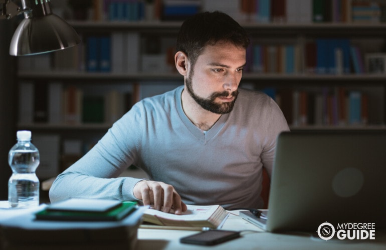 theology degree student studying on his computer at home