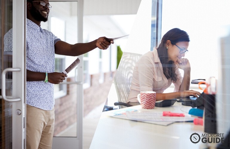 marketing experts giving out flyers and working on laptop respectively