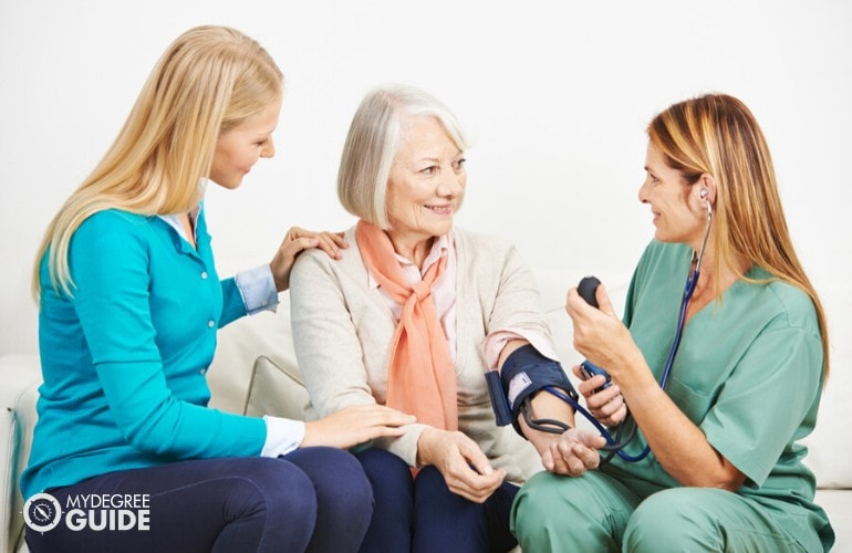 family nurse checking an elderly woman's blood pressure