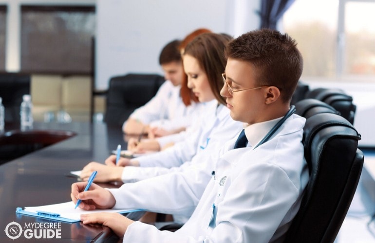 healthcare administrators taking notes during a meeting