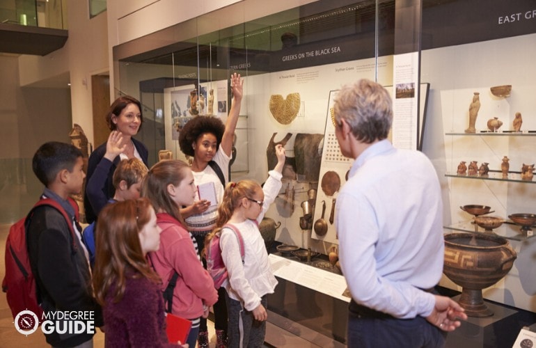 Historian answering questions of young students during a tour